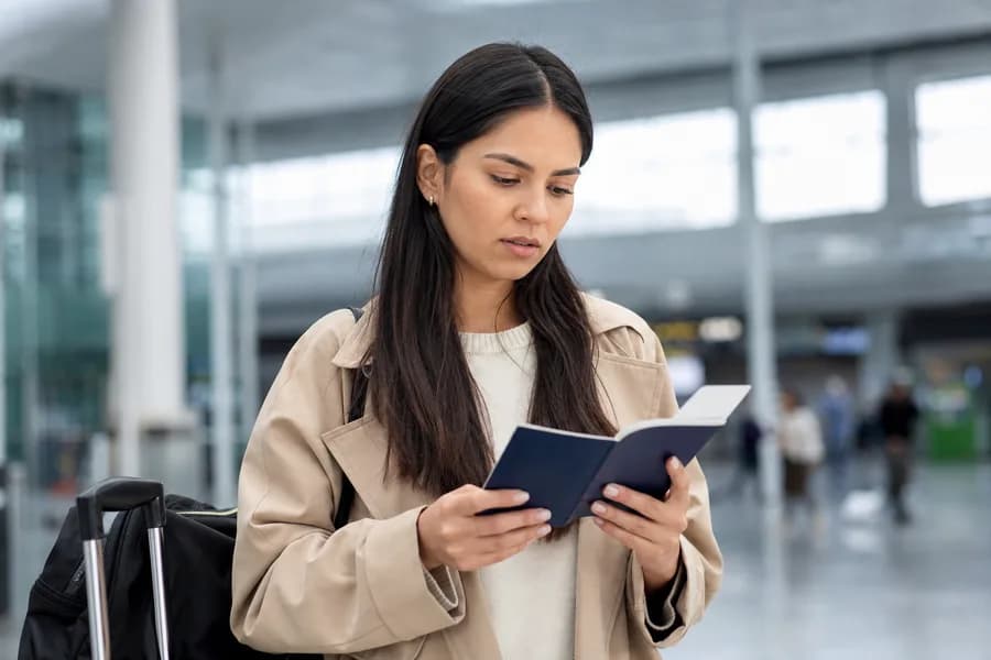 Viajera revisando su pasaporte y documentos migratorios